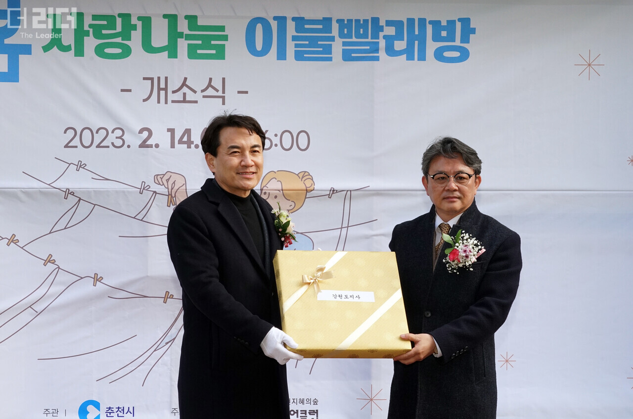 지난 14일 김진태 강원도지사(왼쪽)가 ‘춘천 봄봄 사랑나눔 이불빨래방’ 개소식을 기념해 벽시계를 선물 하고 있다. 전경해 기자